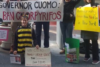Participants of the New York Cuomo Chlorpyrifos rally pose with signs during the event.