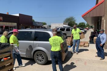 Volunteers load food into a car outside the West Holt Health Ministries (Atkinson-Stuart) food pantry, which distributed 180 boxes to clients on a recent Wednesday.