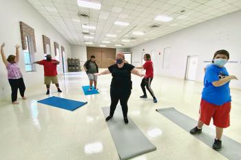 Middle and high students stretch and move with their peers in the new adaptive dance residency led by Arts for Learning.